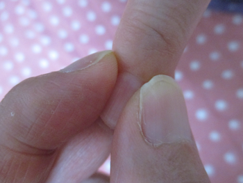 薬指をのぞく4本の指の爪の生え際を押す